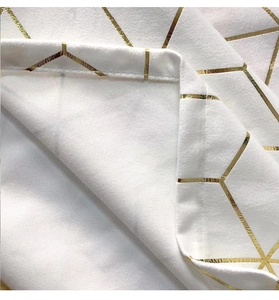 Close-up of gold geometric print on white velvet tablecloth with premium stitched edges