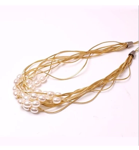 Detail view of multi-strand gold chain curtain tieback with elegant white faux pearls