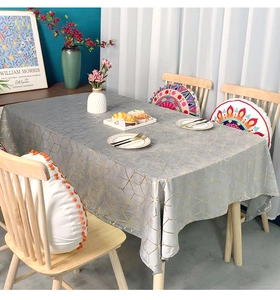 Detail of grey velvet tablecloth with gold geometric patterns in a modern home setting