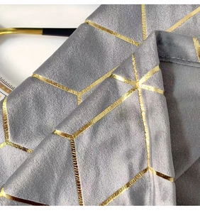 Detail of grey velvet tablecloth with gold geometric patterns and luxury texture