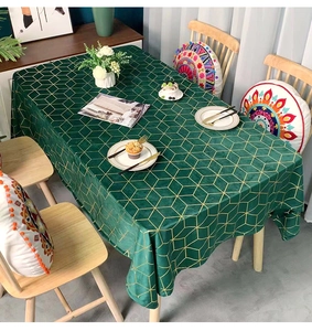 Detail of dark green velvet tablecloth with golden geometric diamond lines and texture