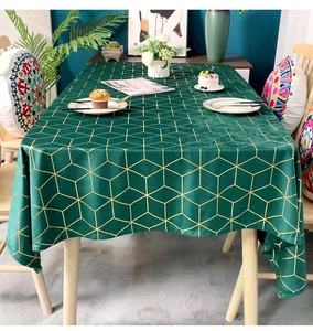 Detail of dark green velvet tablecloth featuring geometric gold foil line patterns