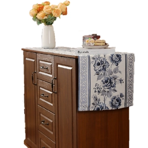 Blue and white floral embroidered table runner on dark wood cabinet for home decoration