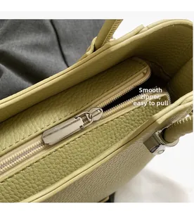 Détail de la fermeture éclair en métal argenté sur le sac fourre-tout en cuir vert