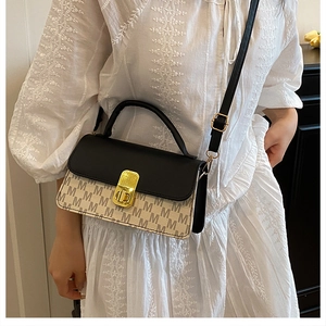 Detail of contrast flap handbag with golden twist lock and signature M letter pattern