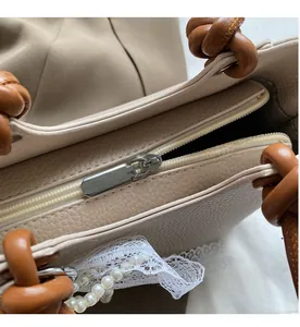 Vue macro détaillée de la fermeture éclair métallique d'un grand sac cabas blanc texturé