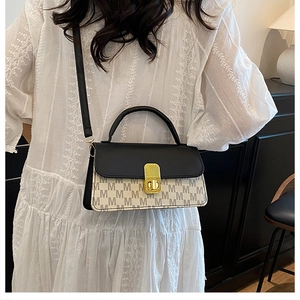 Détail du sac bandoulière bicolore avec imprimé M et fermoir en métal doré