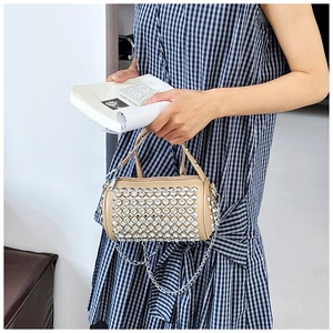 Detailed macro view of the sparkling rhinestone cylinder bag with metallic chain strap
