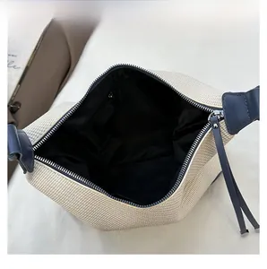 Detail view of woven bag interior with black lining, zipper pocket and leather trim