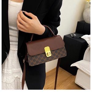 Détail du sac bandoulière avec motif monogramme M marron et fermoir en métal doré