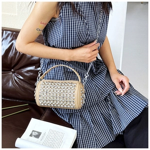 Macro shot of khaki cylindrical handbag with luxury rhinestones and silver chain strap