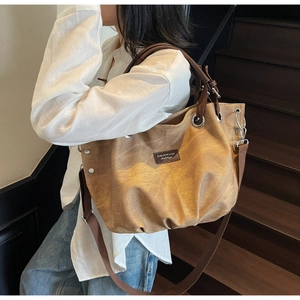 Detailed close-up of a vintage khaki canvas tote bag with adjustable shoulder straps