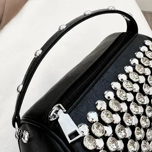 Macro detail van zwarte leren cilinder tas met zilveren studs en metalen ritssluiting
