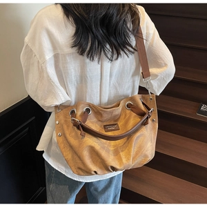 Retro khaki tote bag detail showing pleated texture and silver metal eyelets on the side