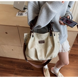 Detailed view of the large capacity vintage tote bag with leather straps and logo patch
