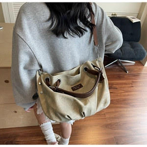 Detailed back view of a large khaki tote bag with silver grommets and brown straps