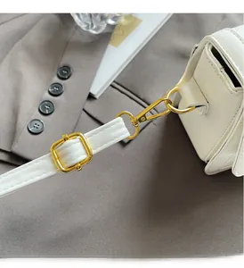 Close-up of premium white leather handbag featuring adjustable strap and gold metal buckle