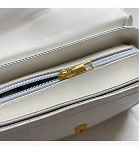 Macro detail of golden metal zipper on premium white quilted leather handbag with inner lining