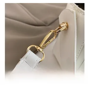 Détail du sac en similicuir blanc avec fermoir mousqueton doré et coutures précises