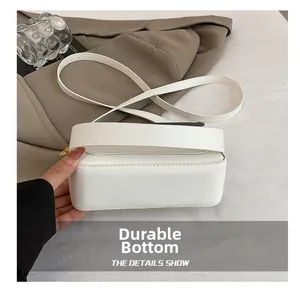 Détail d'un sac à bandoulière blanc avec coutures renforcées et ferrures dorées de luxe