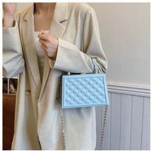 Light blue quilted hard shell handbag with metal handle and gold chain shoulder strap