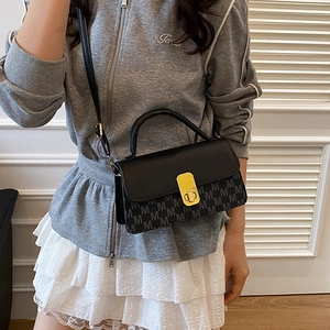 Chic black crossbody bag with letter print design and golden buckle on model