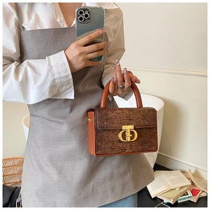 Dettaglio borsa a scatola in pelle marrone con chiusura a fibbia dorata a forma di D