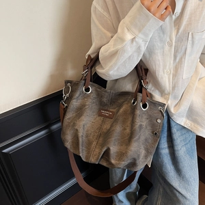 Vintage taupe canvas tote bag with brown leather handles and side rivet details