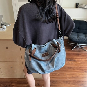 Retro washed blue canvas tote bag with brown straps shown in a cozy home office setting