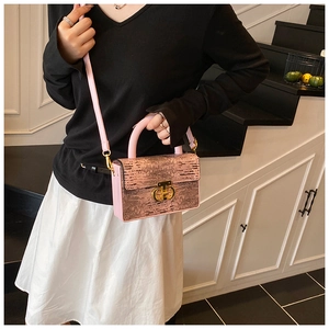Dettaglio della texture rosa metallizzato e chiusura dorata sulla borsa chic