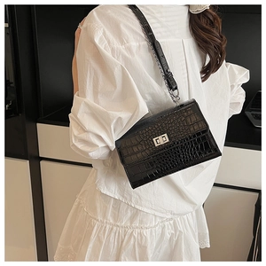 Detail showing crocodile texture and silver metal lock on a black square shoulder bag