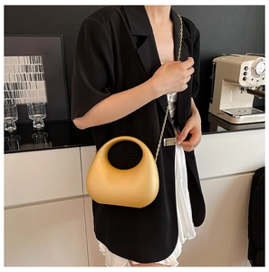 Fashionable mustard yellow acrylic moon bag with golden chain and circular handle detail