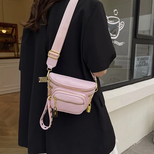 Borsa a tracolla rosa in pelle con catena dorata e ampia tracolla indossata da modella
