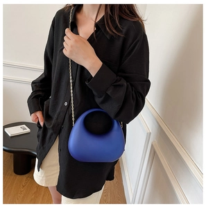Detail of Klein blue crescent acrylic evening bag with delicate gold chain strap