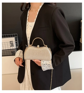 Elegante champagne clutch met lovertjes, goudkleurig handvat en parelsluiting