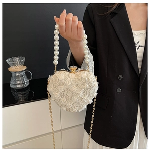 Detail of heart-shaped lace bag with 3D rose appliques and elegant pearl handle