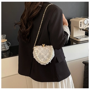 Detailed back view of heart lace bag with pearls on a model in a modern interior