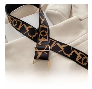 Detail of adjustable shoulder strap with vintage monogram and gold-tone metal buckle