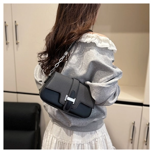 Detail of vintage black crossbody bag featuring a silver H-shaped metal buckle and strap