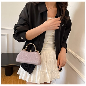 Detail van roze glitter avondtas met gouden metalen handvat en crossbody ketting