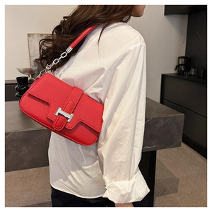 Close-up of red leather and fabric patchwork shoulder bag with silver H-shaped clasp