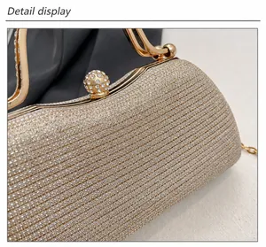 Close-up of champagne evening bag featuring wavy texture and rhinestone ball clasp