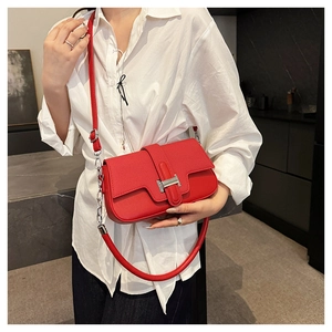 Close-up of red lychee pattern leather bag featuring a silver H-shaped metal clasp buckle