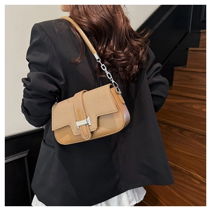 Detail of vintage brown patchwork crossbody bag with silver buckle and metal chain strap