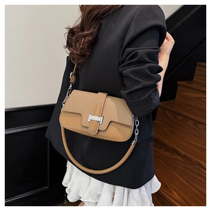 Detail of canvas bag with camel leather trim and silver H-shaped metal buckle clasp