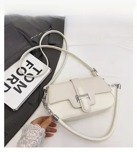Detail of ivory faux leather crossbody bag with silver lock and dual strap options