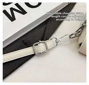 Detail of adjustable white leather strap with silver metal buckle and lobster clasp hook