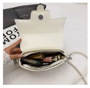 Detail view of the interior compartment and zipper pocket of the white vintage crossbody bag