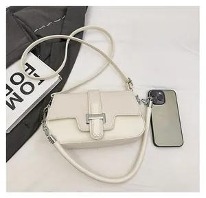 Detail view of beige leather crossbody bag with woven texture flap and metal buckle