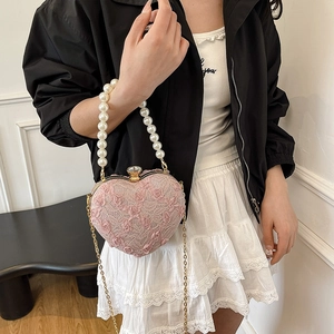 Pink heart-shaped lace bag with 3D roses, pearl handle and gold chain on model